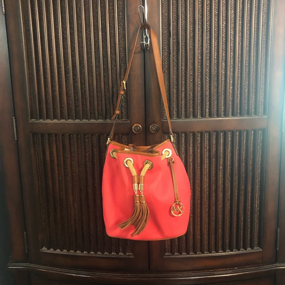 Michael Kors adjustable shoulder strap or cross body tasseled bucket bag.